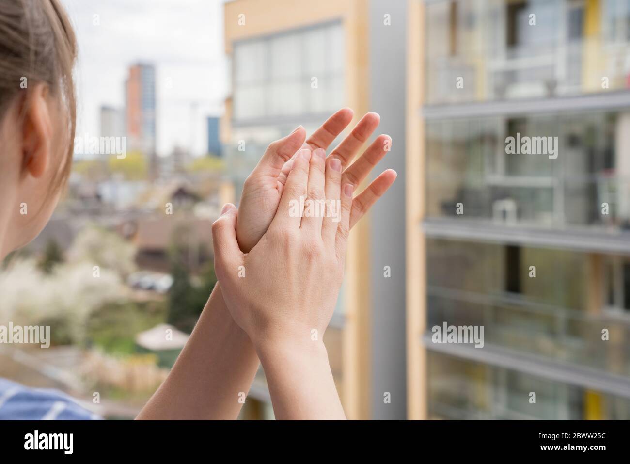 Crop view of woman clapping hands on balcony Stock Photo