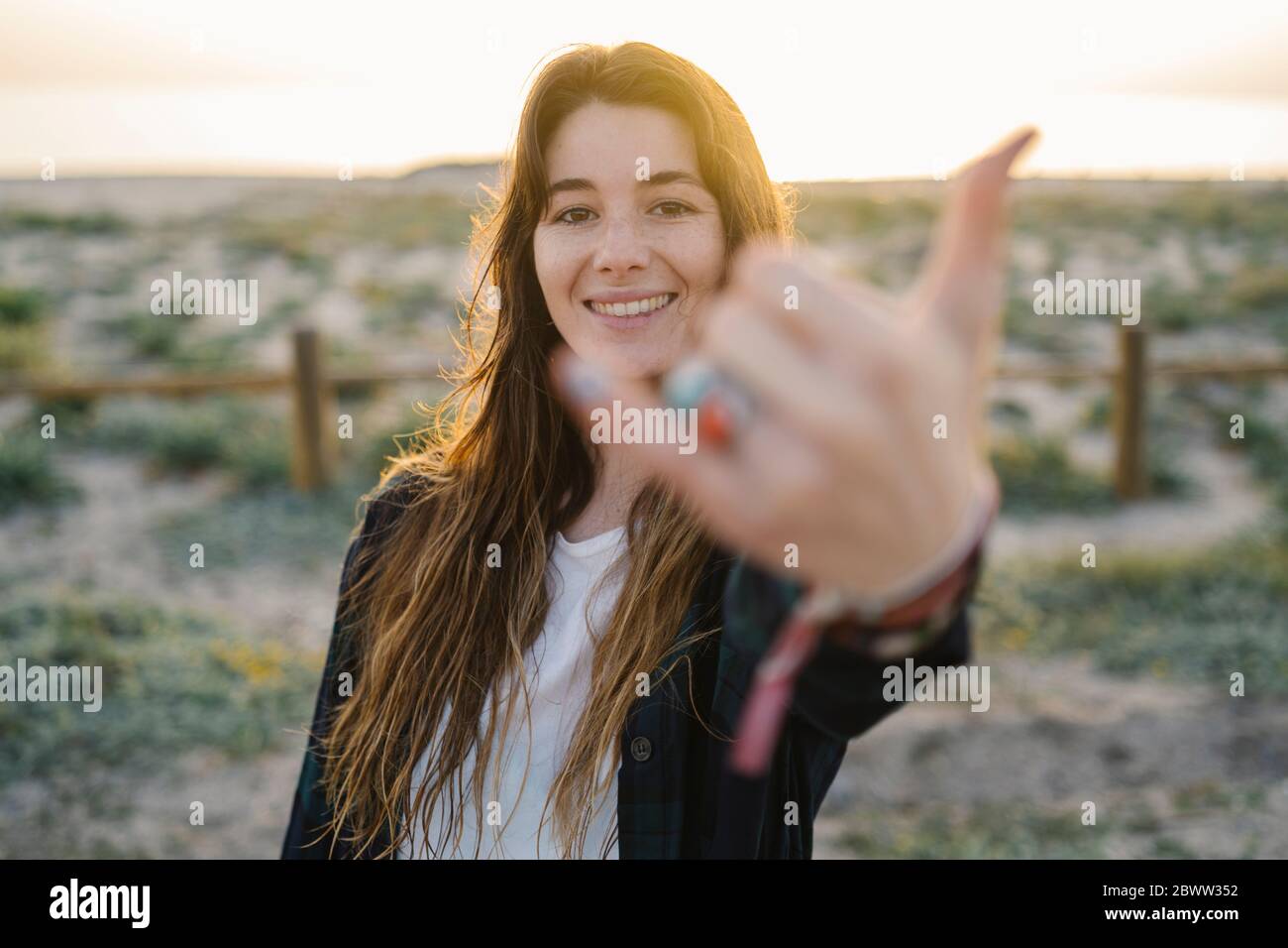 Portrait of smiling young woman  showing shaka sign Stock Photo