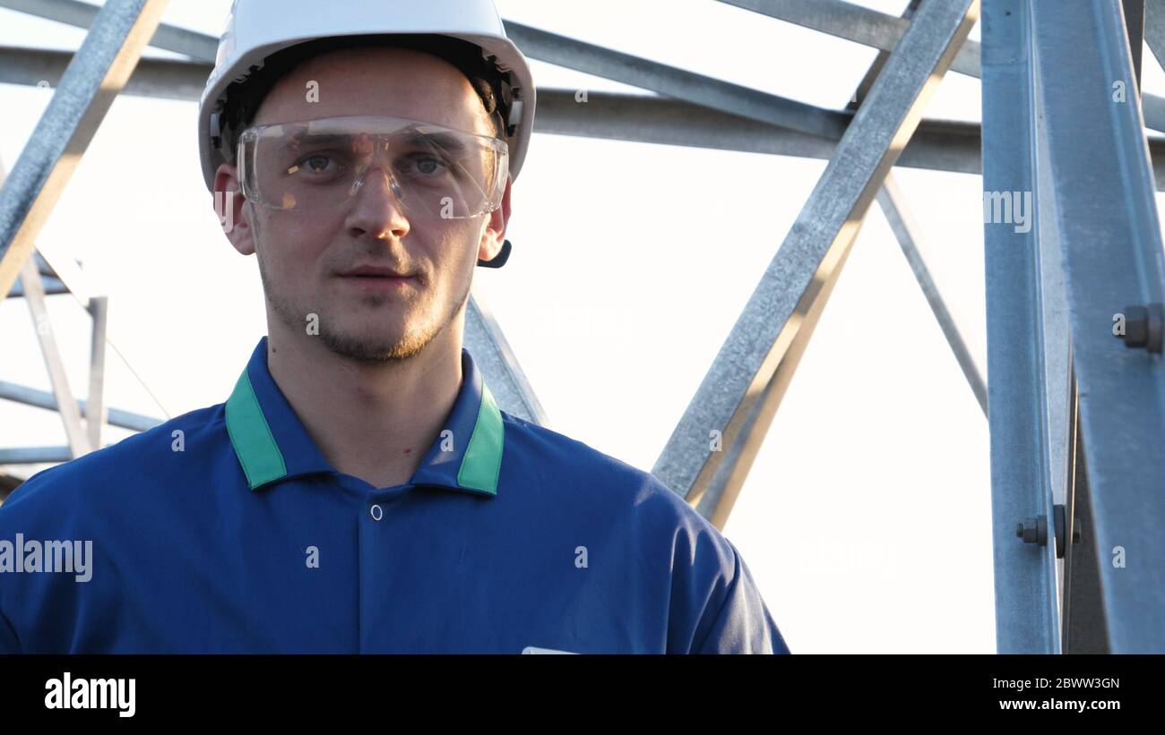 An electrician or builder and engineer, in a blue robe, in a yellow and ...