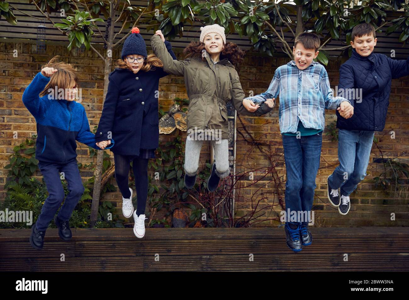 Group of children jumping on the schoolyard during break time Stock Photo