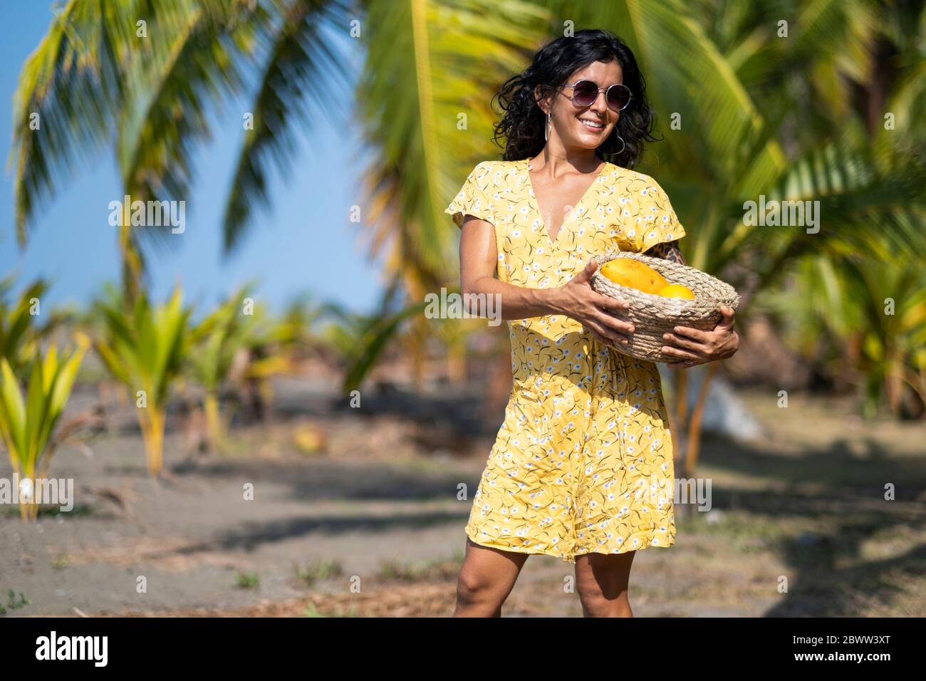 Young woman holding a fruit basket at the beach, Costa Rica Stock Photo ...