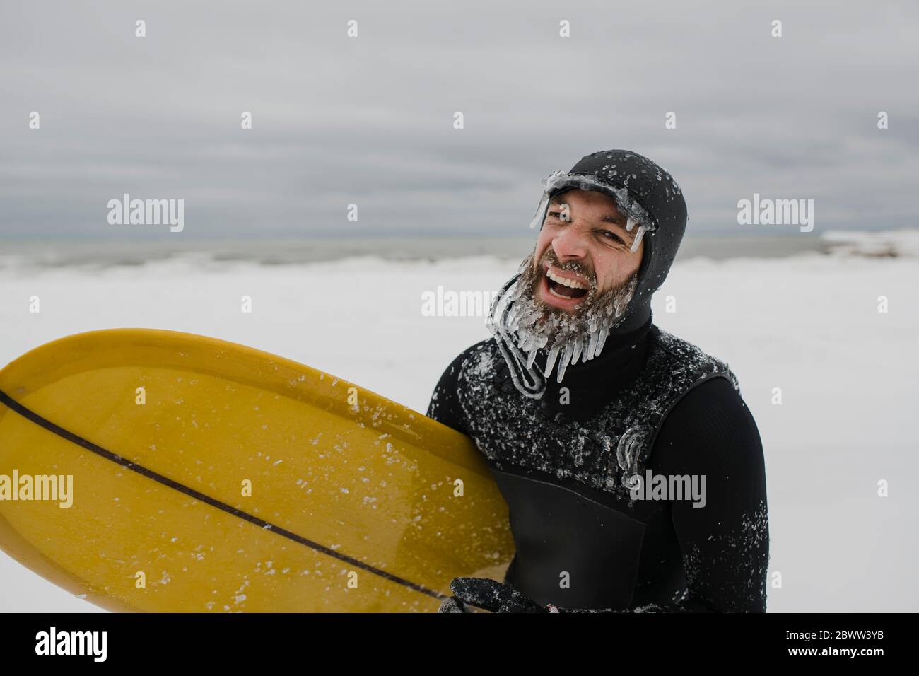 Surfer with surfboard in snow in Ontario, Canada Stock Photo