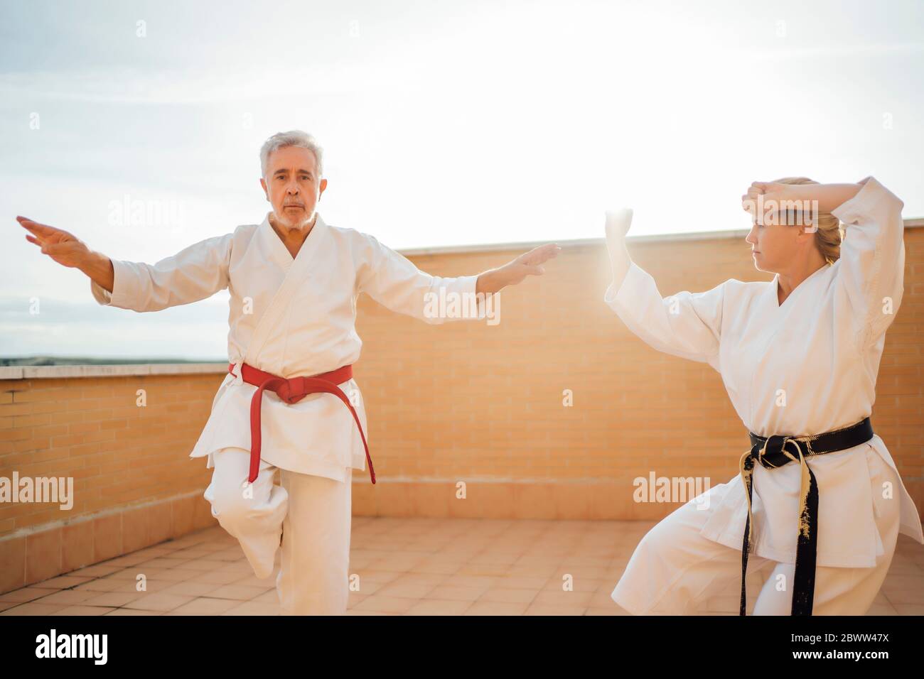 Woman with teacher during karate training on terrace Stock Photo