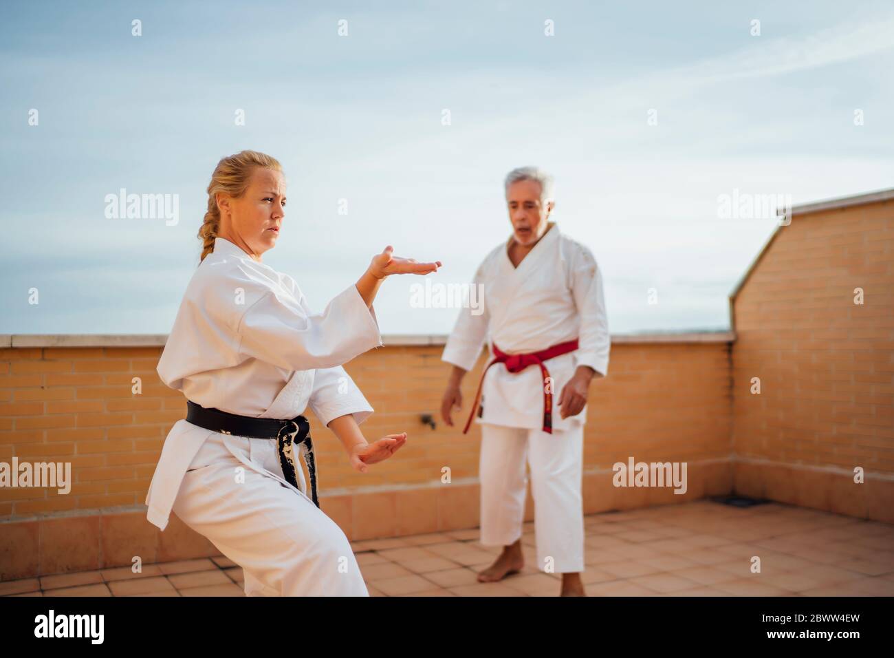 Woman with teacher during karate training on terrace Stock Photo
