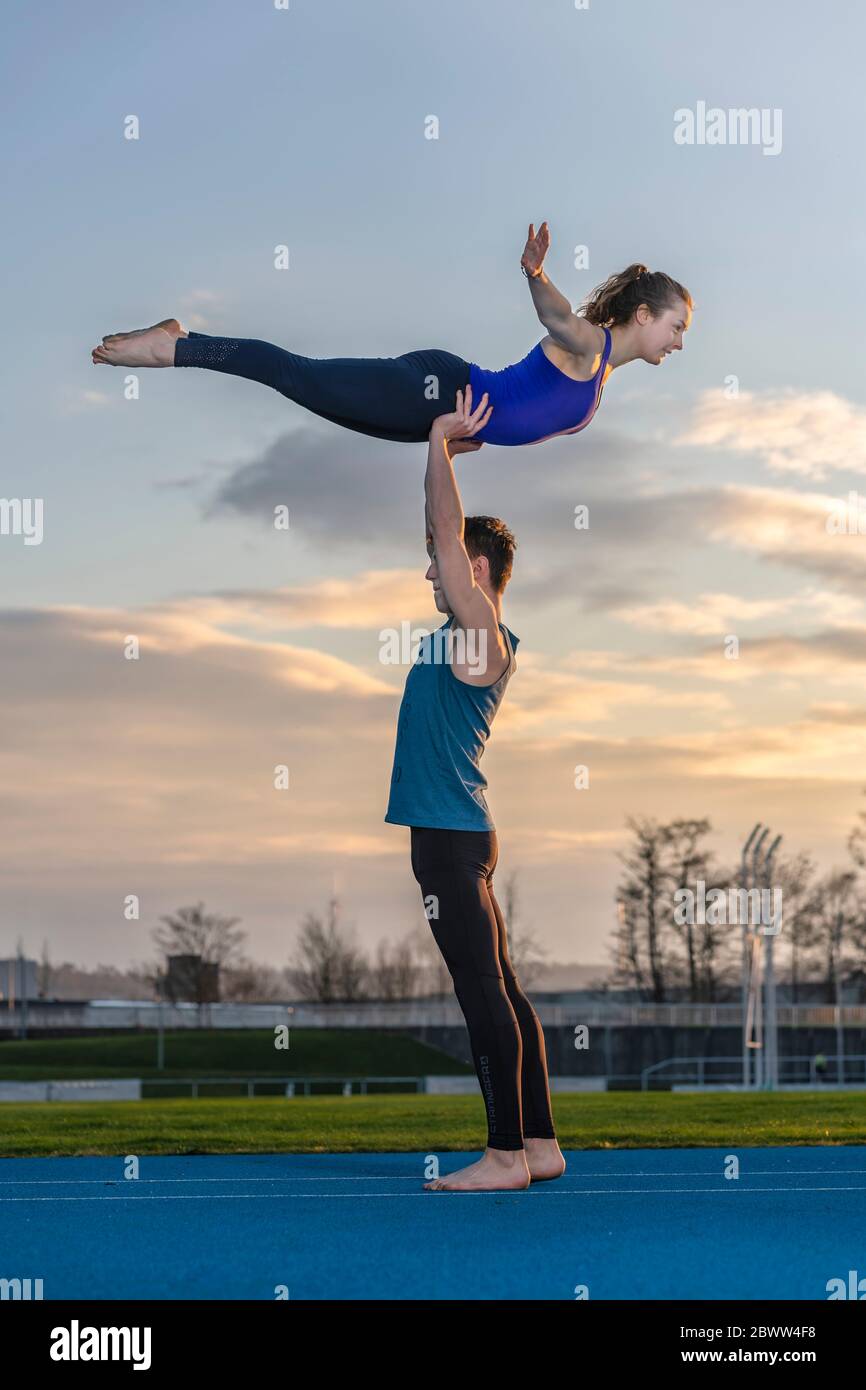 Two athletes performing duo acroyoga poses Stock Photo by Photology75