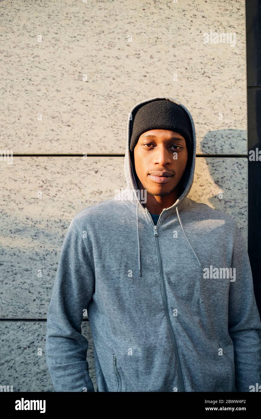 Portrait of confident young man at a grey wall Stock Photo - Alamy