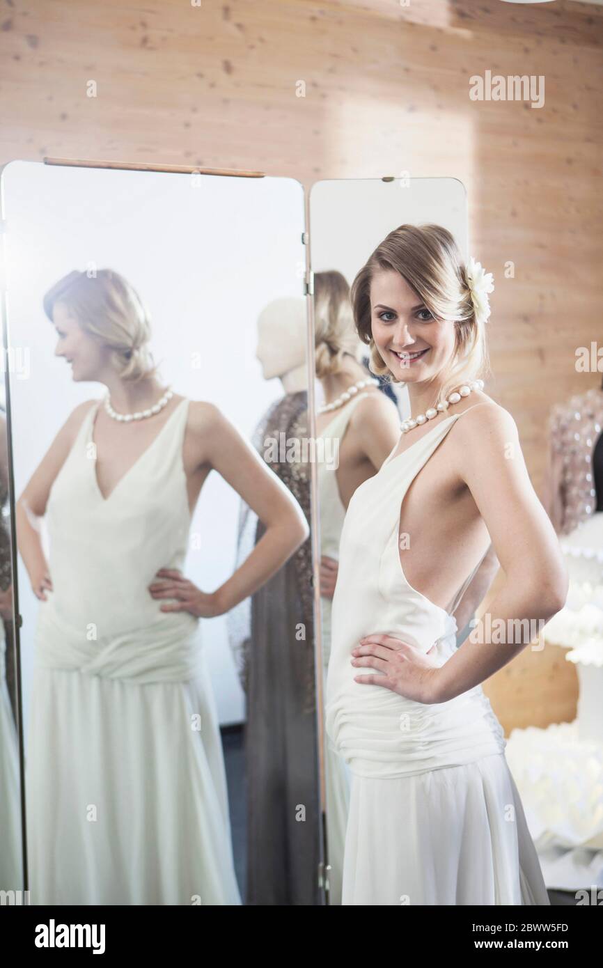Smiling bride fitting her dress in studio Stock Photo