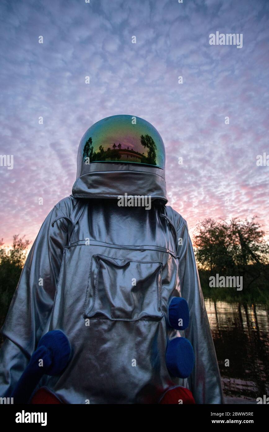 Portrait of spacewoman looking up at sunset Stock Photo