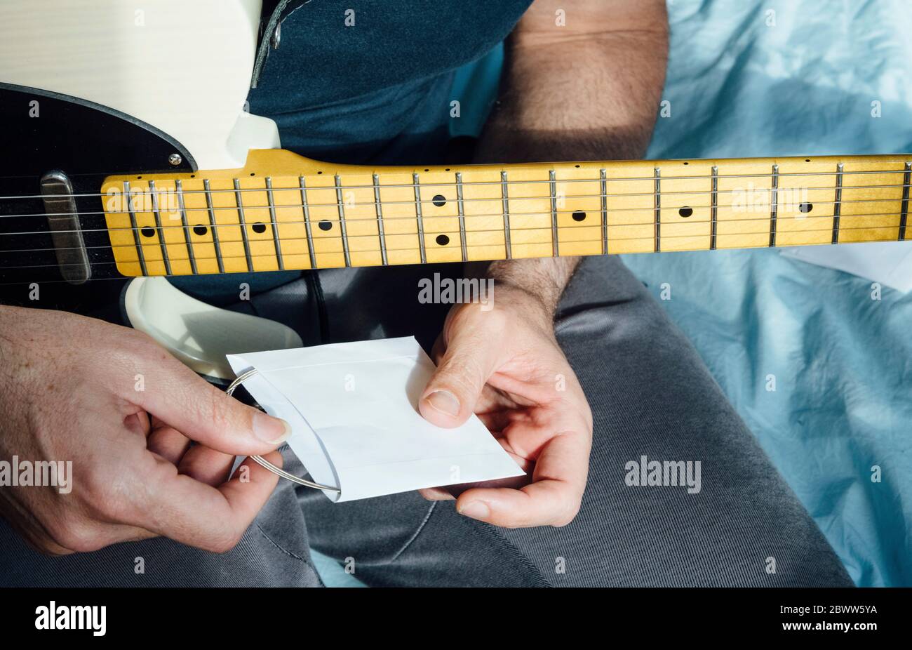 Man learning to play electric guitar with cd Stock Photo