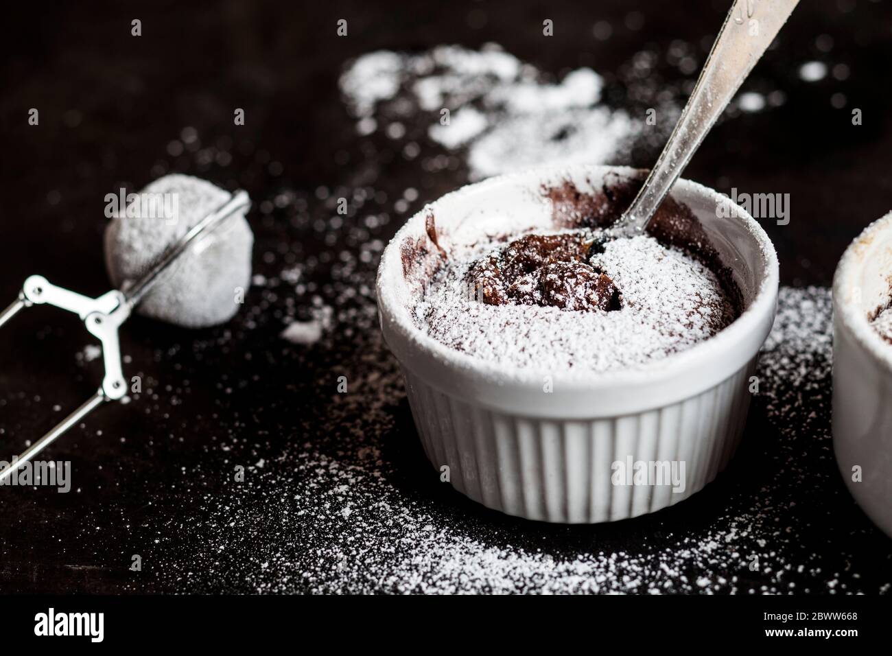 Studio shot of mug of molten chocolate cake with powdered sugar Stock Photo