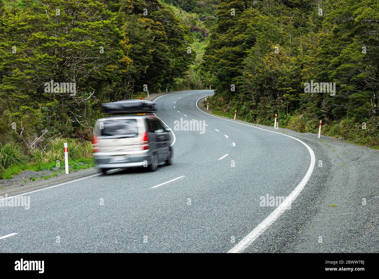New Zealand, Southland, Blurred motion of car driving along State Highway 94 in Fiordland National Park Stock Photo