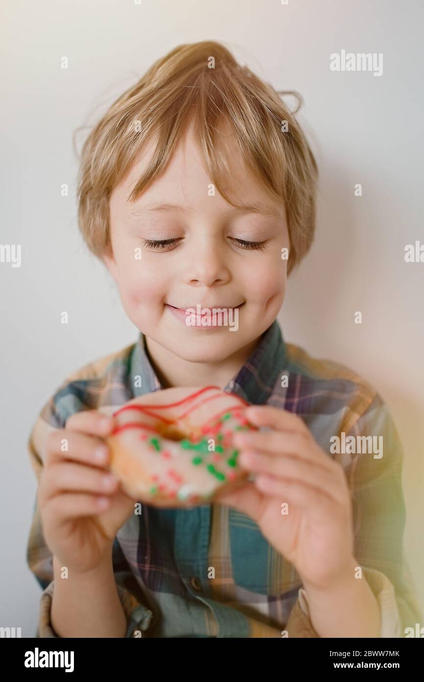 Cute little boy looks with an appetite for a donut Stock Photo