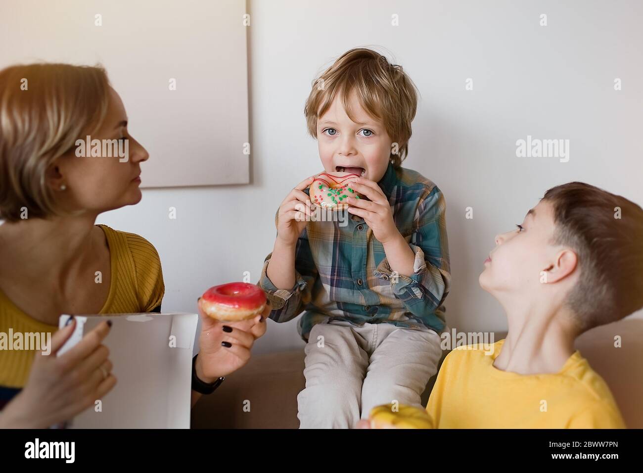 Happy cute boy is eating donut Stock Photo