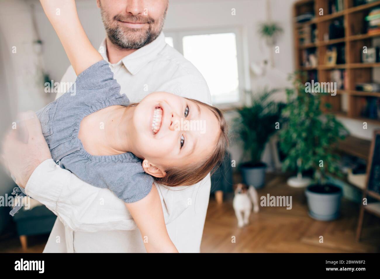 Father playing with daughter, pretending to fly Stock Photo