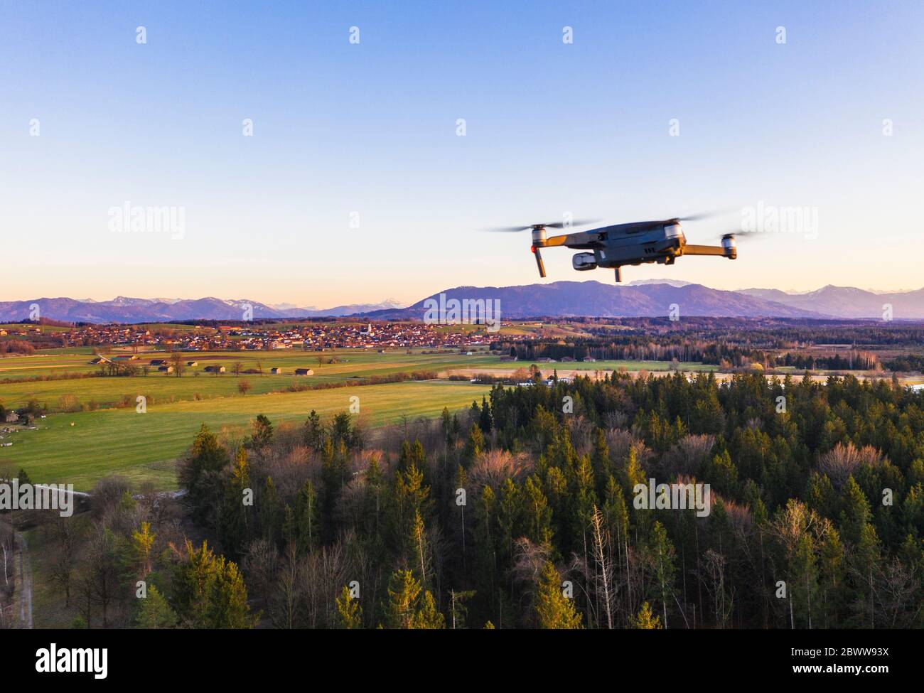 Germany, Bavaria, Konigsdorf, Drone flying over rural grove at dusk Stock Photo