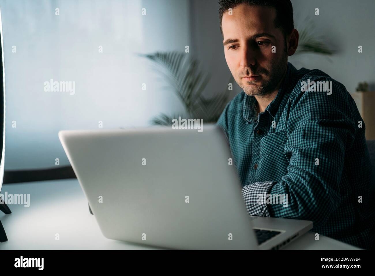 Vlogger using laptop at home Stock Photo