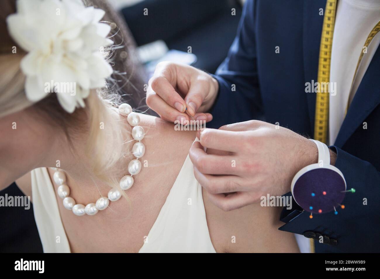 Tailor pinning bridal dress Stock Photo