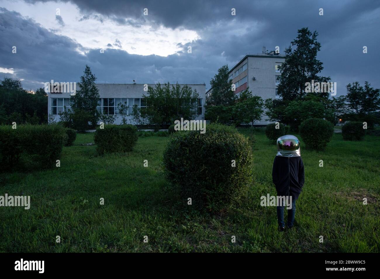 Spaceman standing on meadow in the city Stock Photo