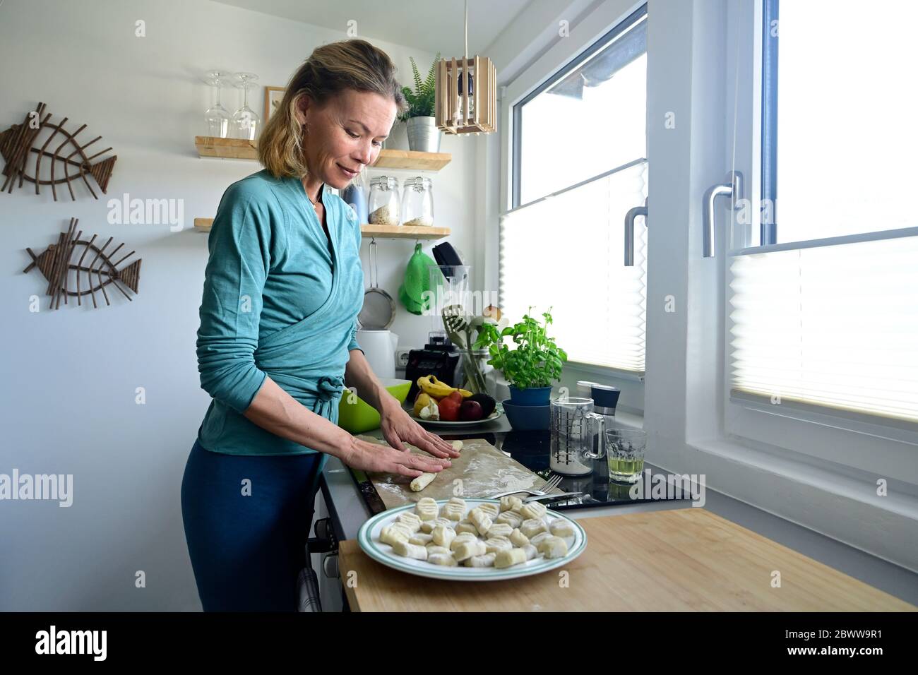 Woman preparing gnocchi in kitchen Stock Photo
