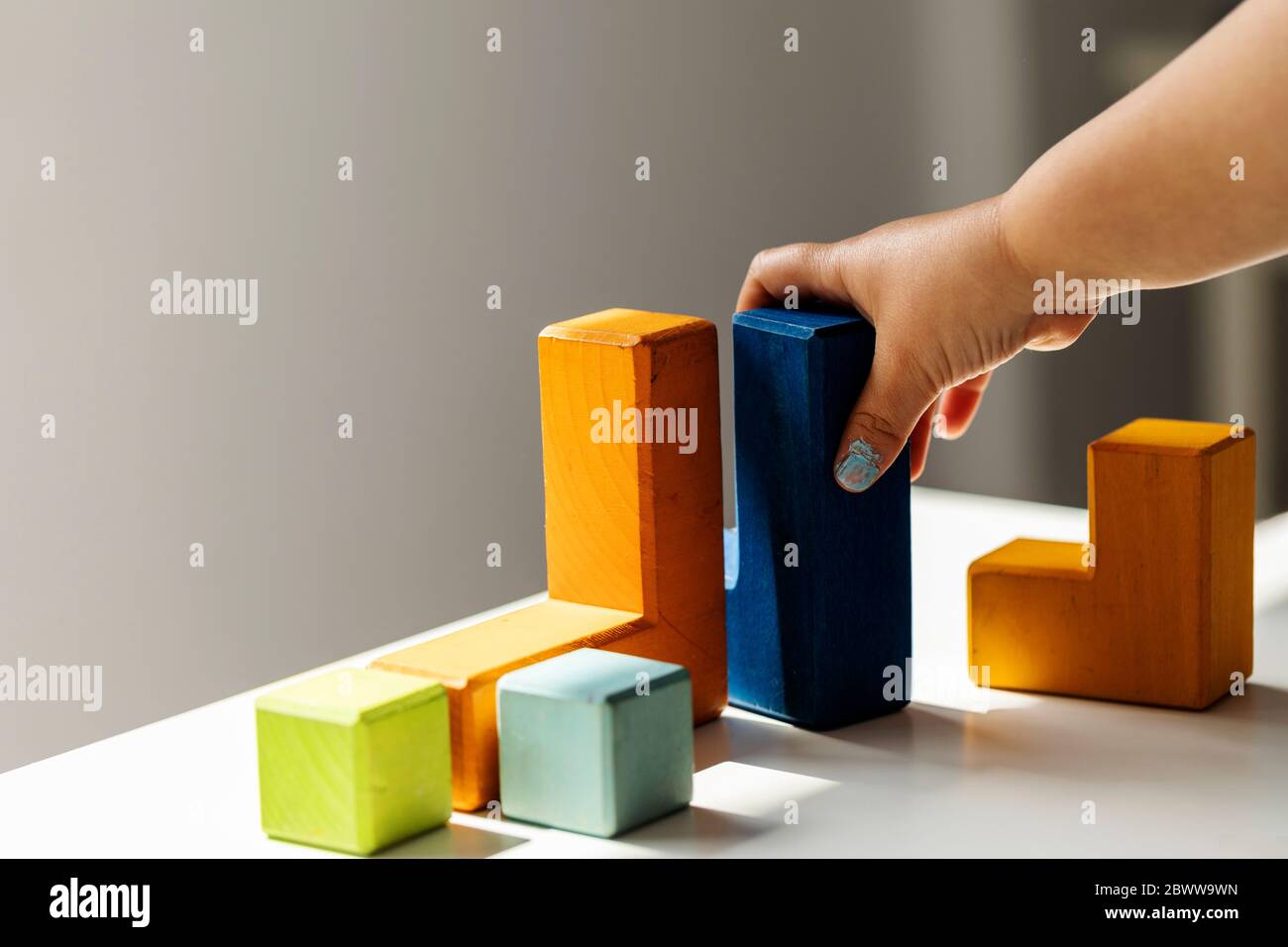 Girl playing with colorful building blocks at home Stock Photo