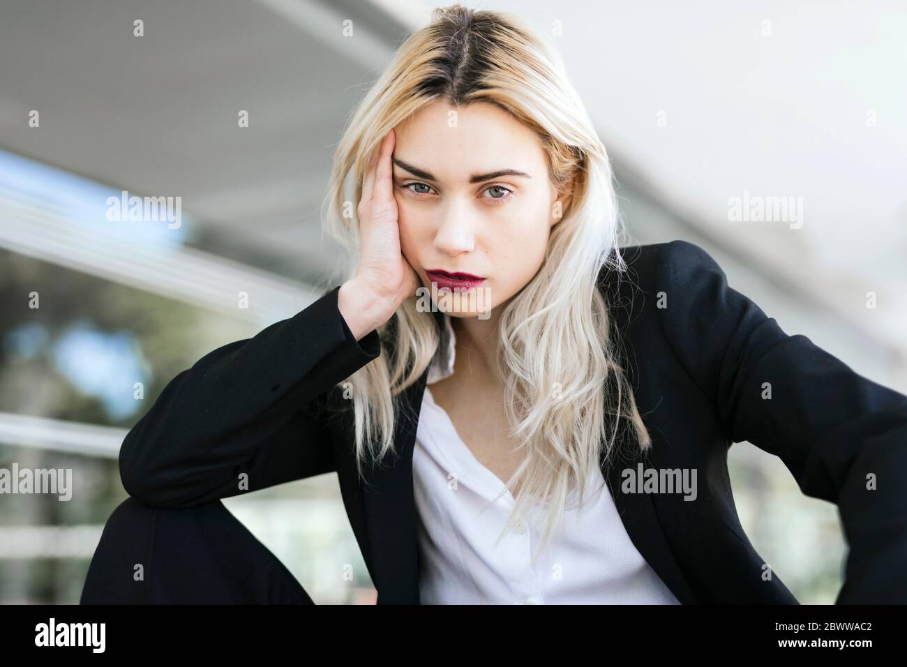 Portrait of young businesswoman with dyed blond hair wearing black pantsuit Stock Photo