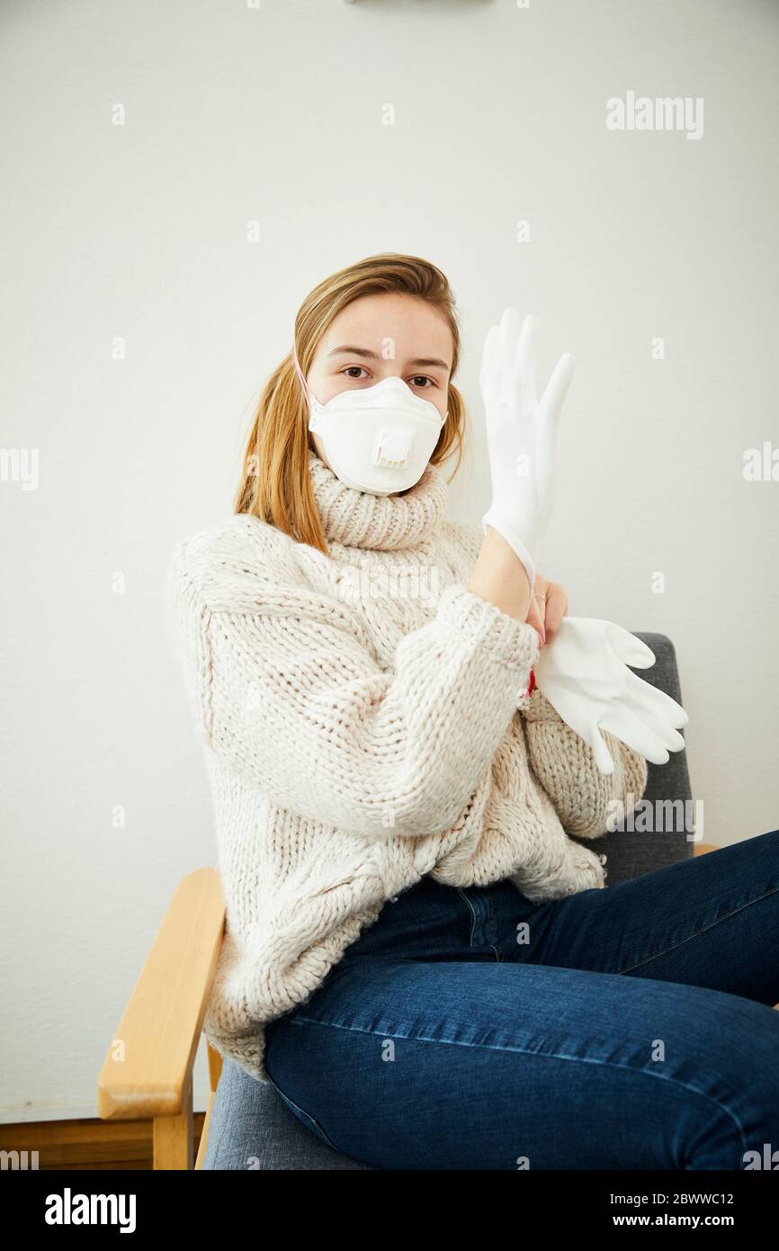 Portrait of blond woman wearing FFP2 mask at home Stock Photo