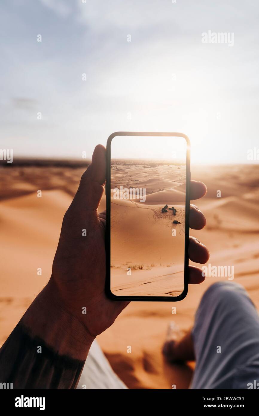 Hand holding smartphone with foto of the desert Stock Photo