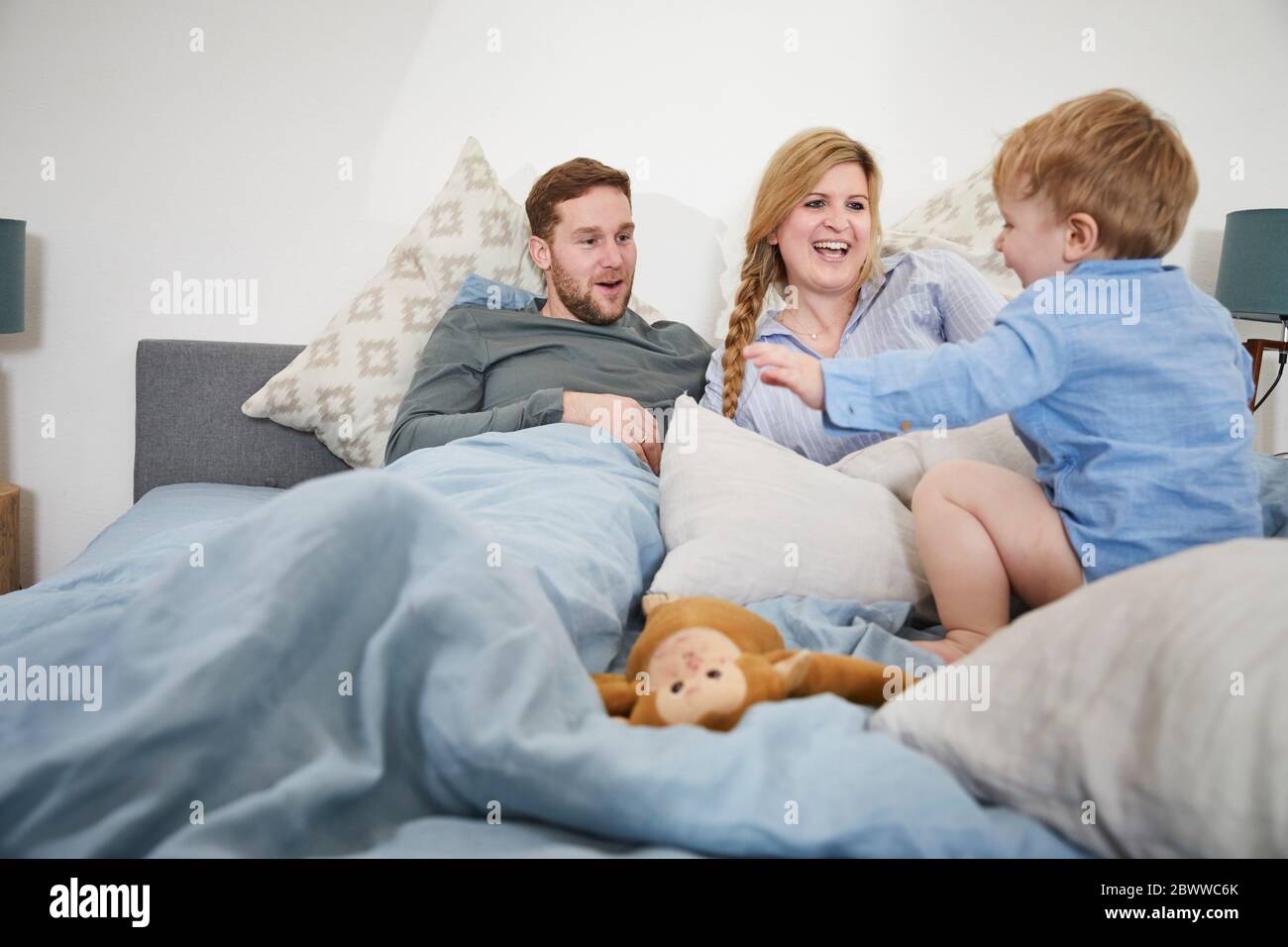 Family relaxing and jumping on bed Stock Photo