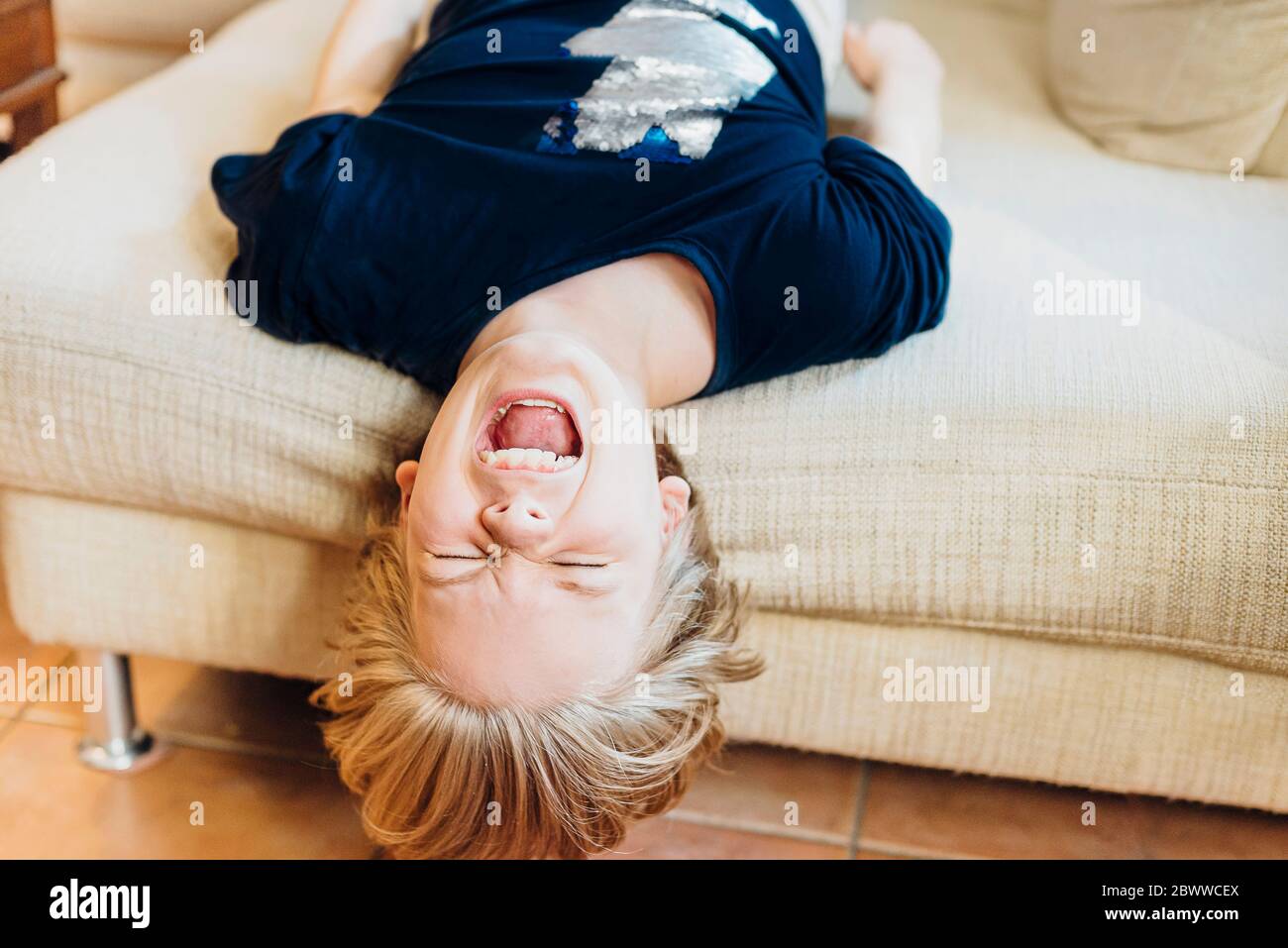 Screaming boy lying on couch Stock Photo