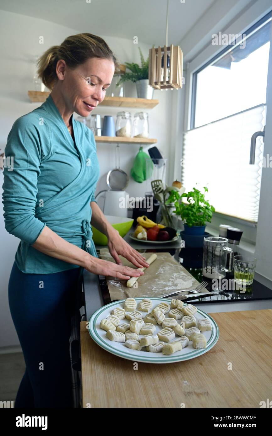 Woman preparing gnocchi in kitchen Stock Photo