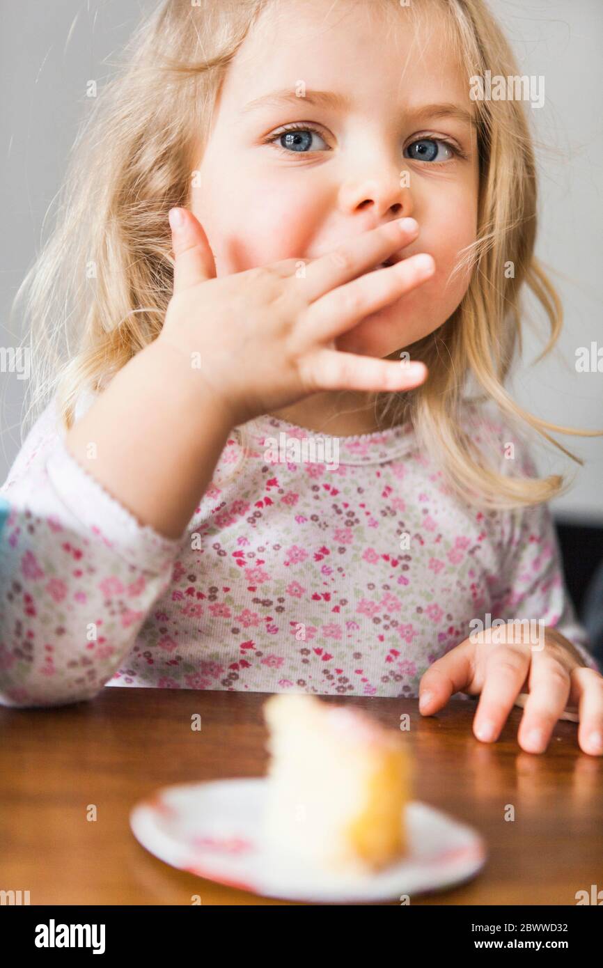Girl eating a piece of birthday cake Stock Photo Alamy