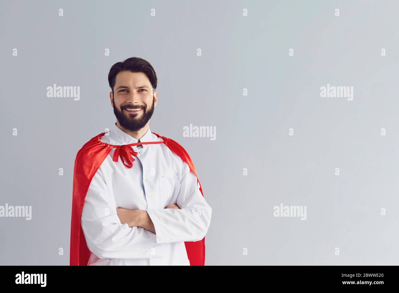 Smiling doctor superhero on a gray background. Stock Photo