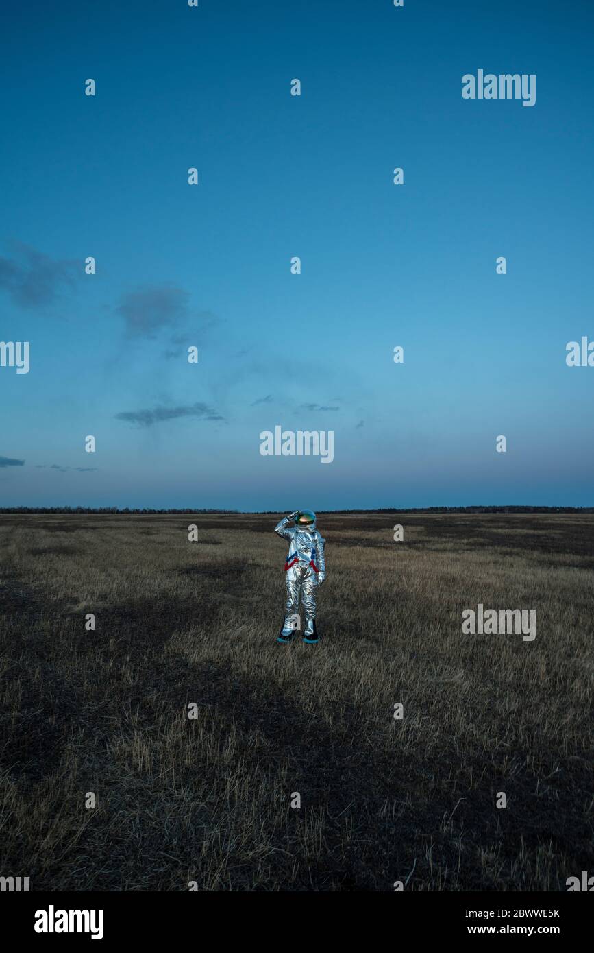 Spacewoman on meadow in the evening Stock Photo