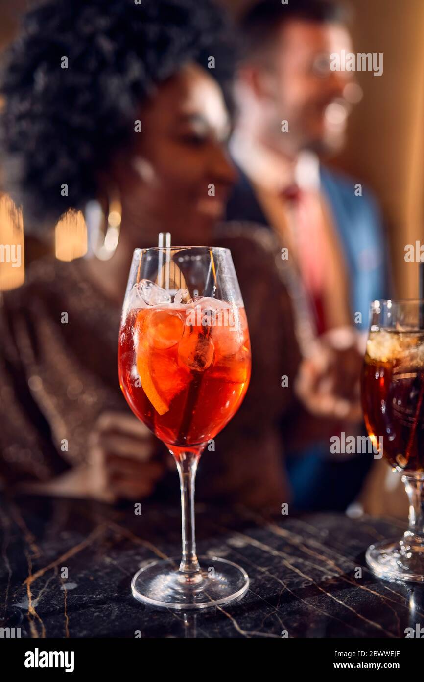 Cocktail glass on counter in a bar with happy people in background Stock Photo