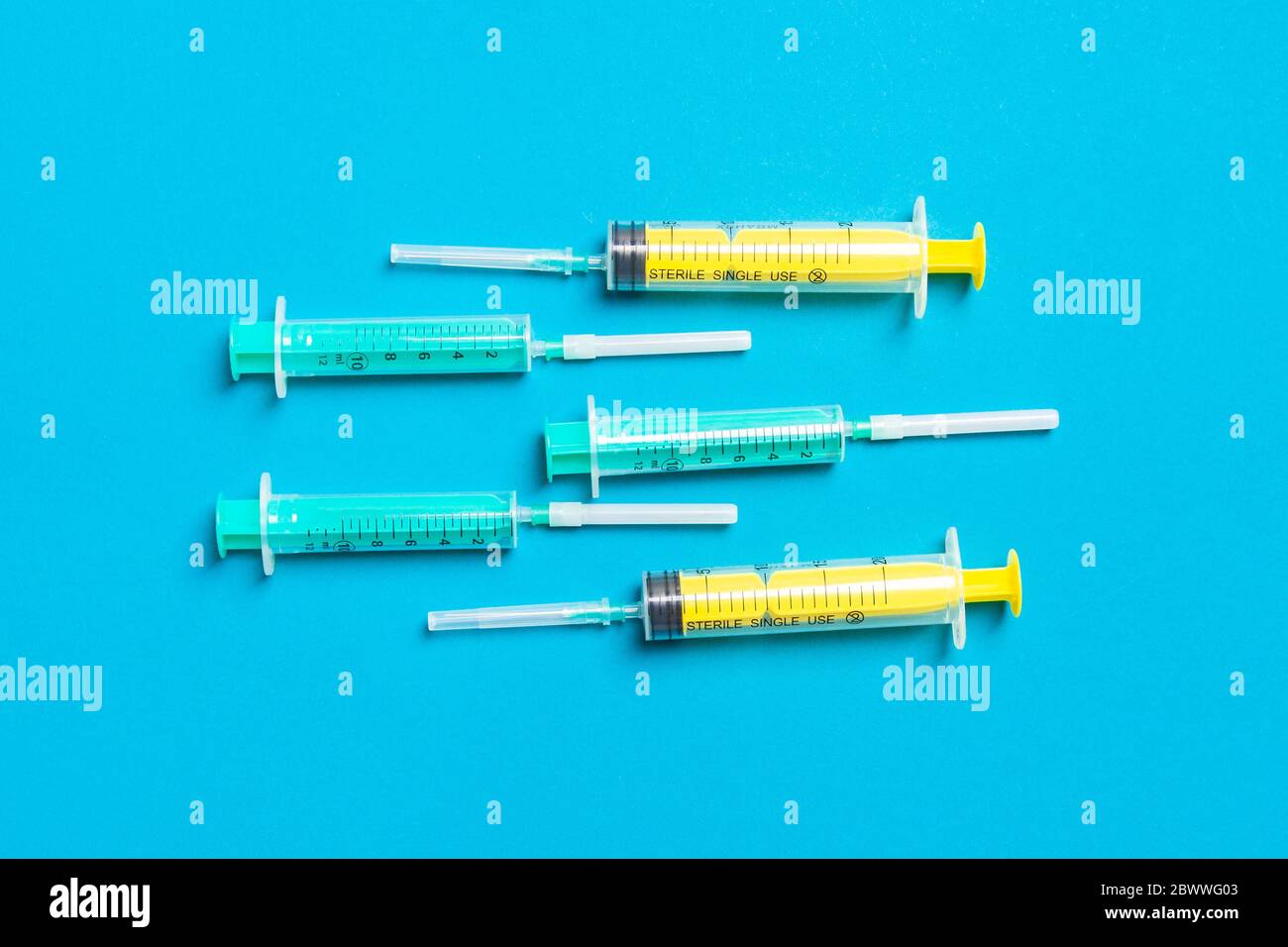 Top view of medical syringes with needles at blue background with copy ...