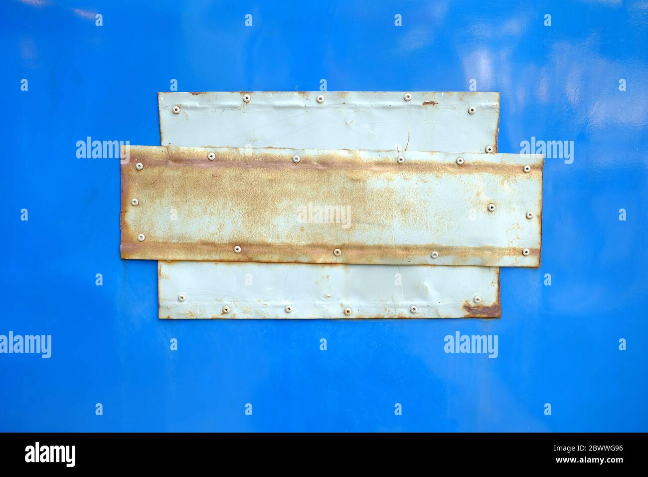 Aluminium Patch on Blue Cabinet. Stock Photo