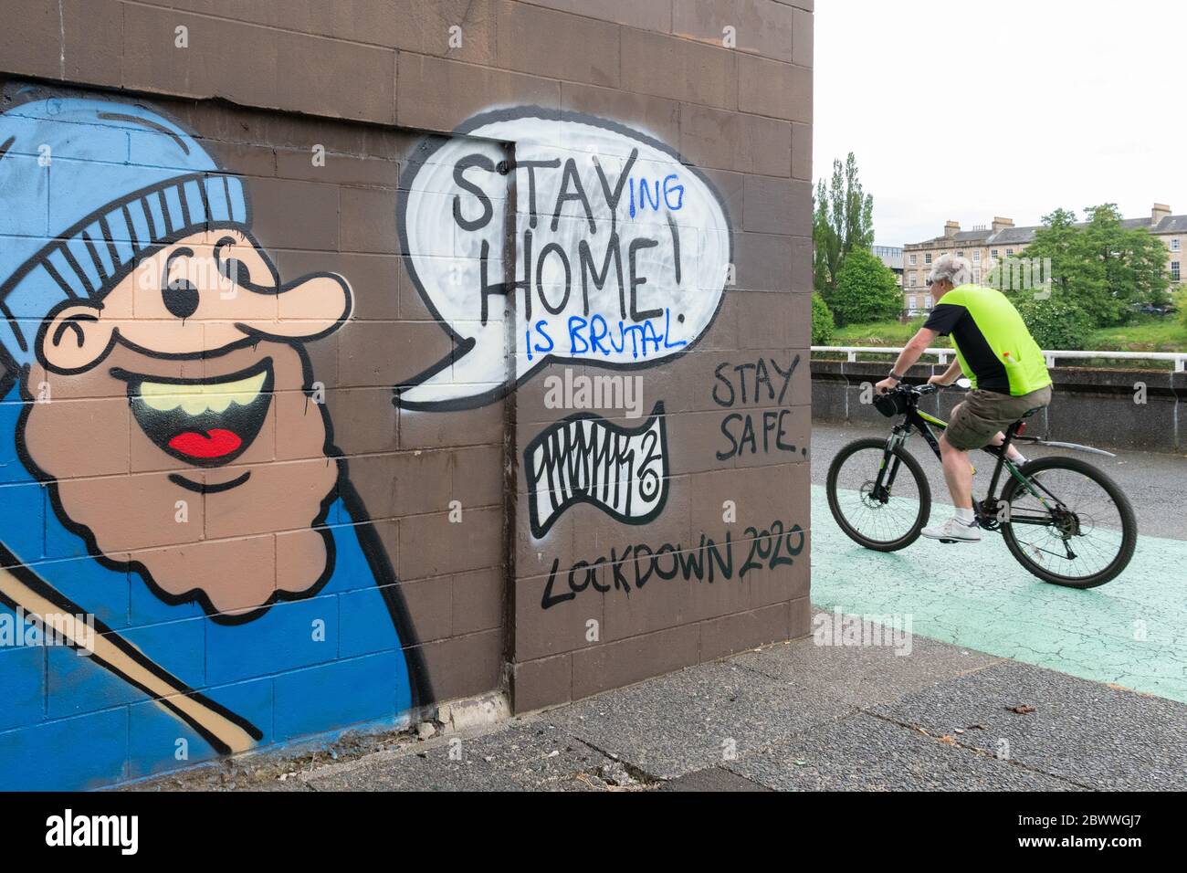 'Stay Home' graffiti  altered to read 'staying home is brutal' - Glasgow, Scotland, UK Stock Photo