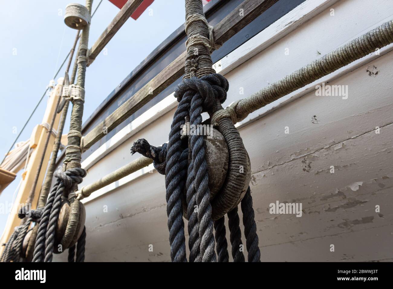 Vintage block and tackle with wrapped ropes against the hull of an old