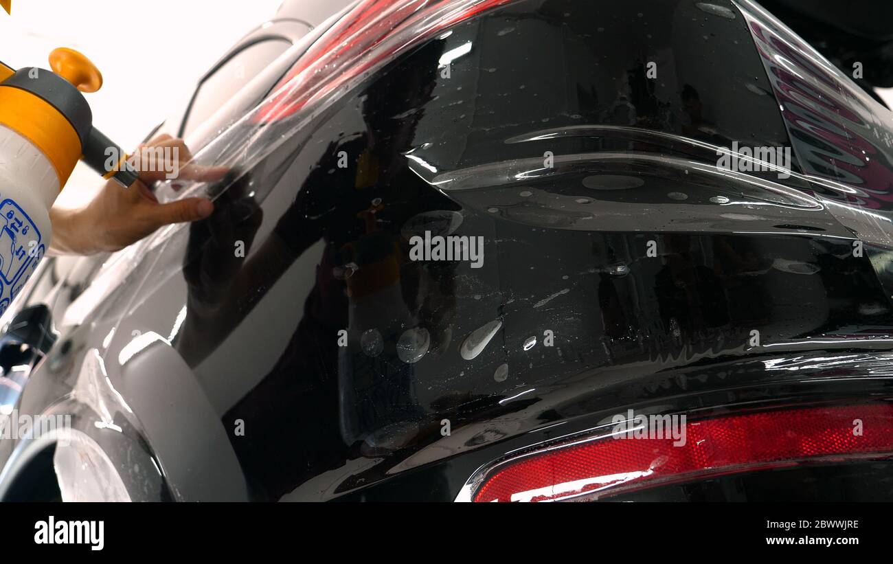 Close up to PPF installation process on a front headlight and hood. PPF is  a Paint Protection Film which protect paint from scratches and stone chips  Stock Photo - Alamy