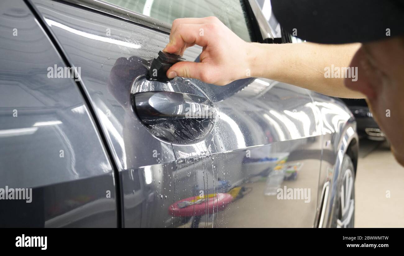 Close up to PPF installation process on a front headlight and hood. PPF