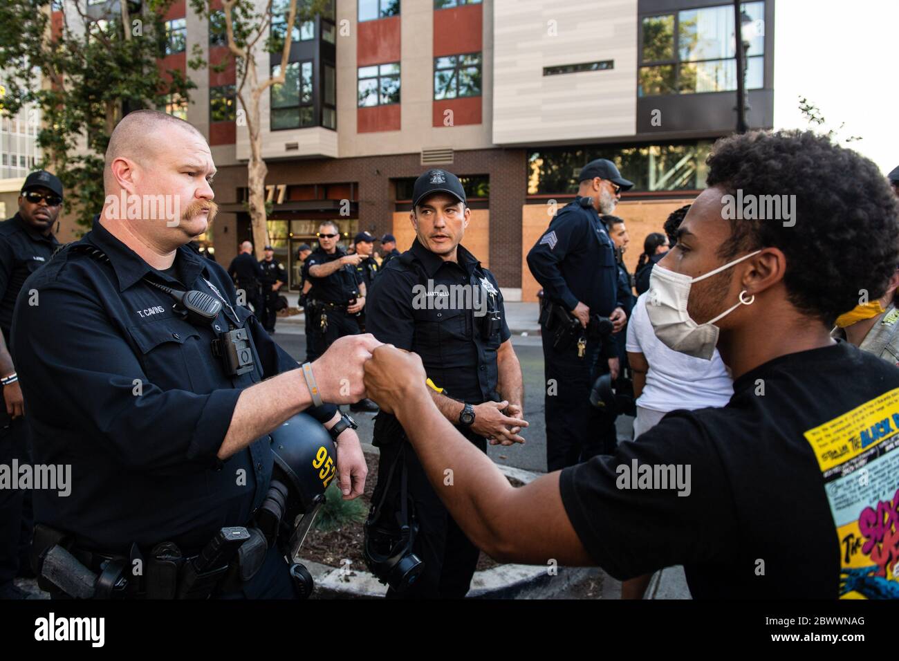 Oakland, Ca. 2nd June, 2020. An Oakland Police Officer and protestor share a fist bump in solidarity near the Oakland Police Department in Oakland, California on June 2, 2020 after the death of George Floyd. Credit: Chris Tuite/Image Space/Media Punch/Alamy Live News Stock Photo
