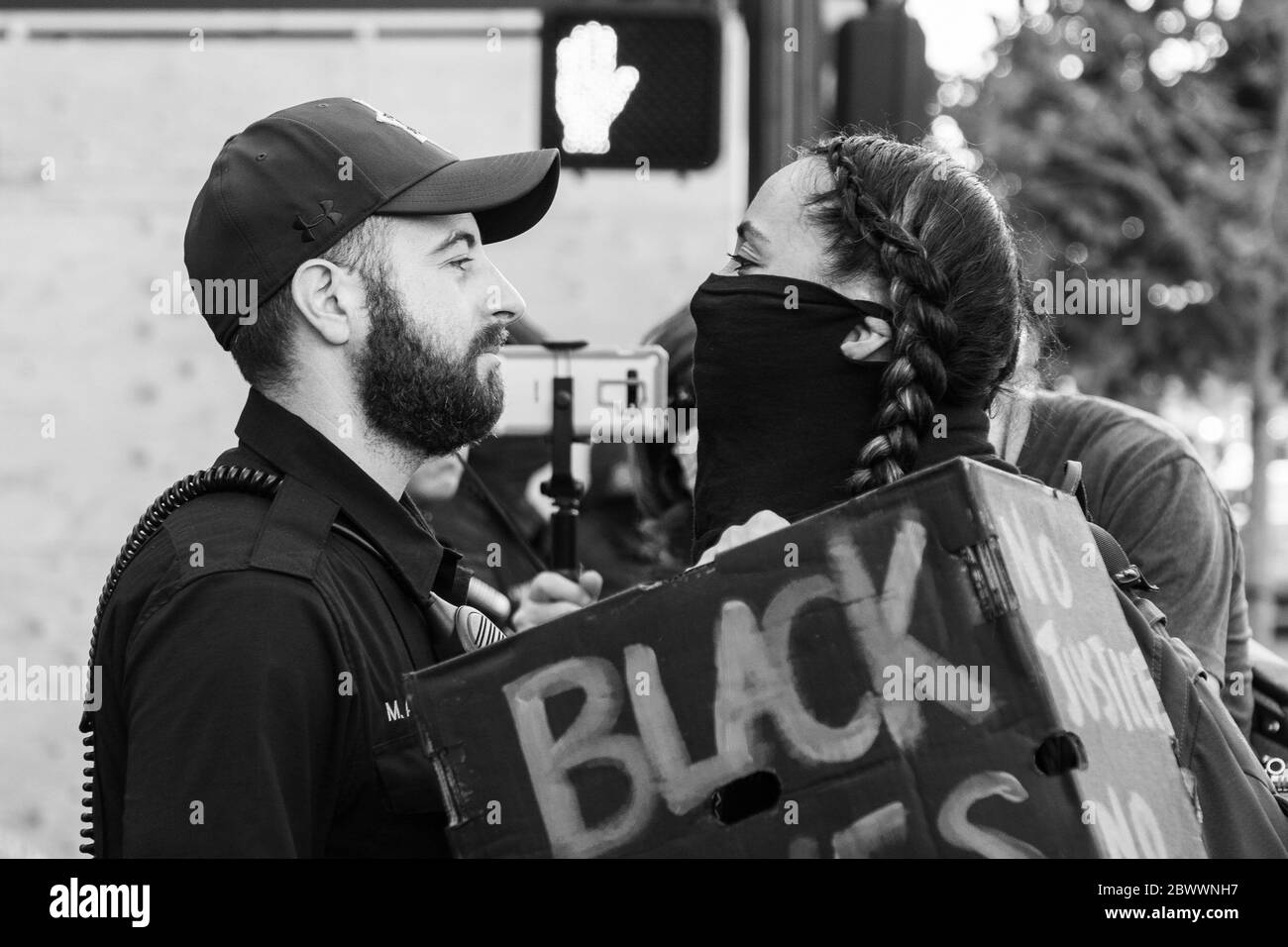 Oakland, Ca. 2nd June, 2020. An Oakland Police Officer and a protestor have a staredown near the Oakland Police Department in Oakland, California on June 2, 2020 after the death of George Floyd. Credit: Chris Tuite/Image Space/Media Punch/Alamy Live News Stock Photo