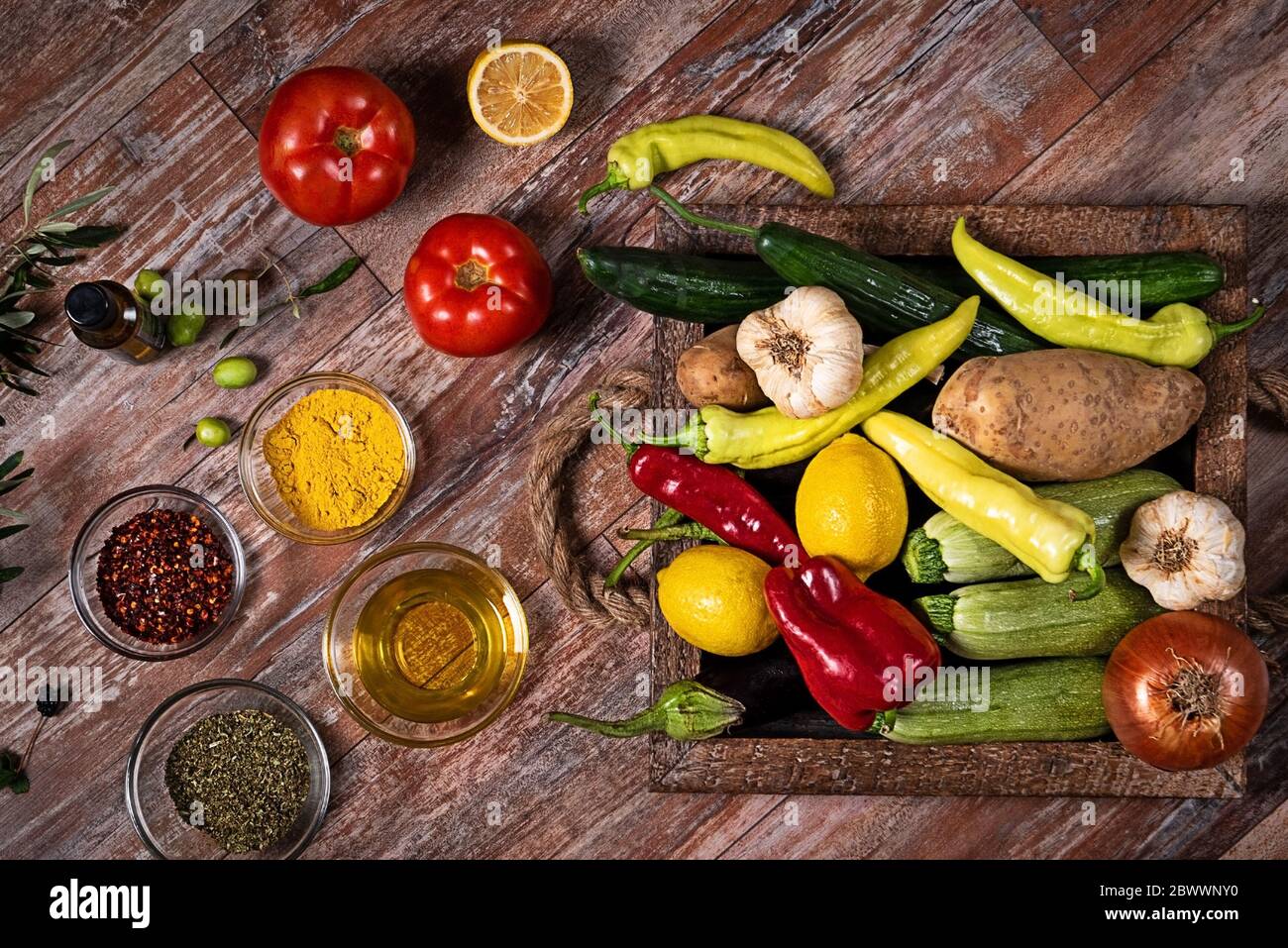 Top view of kitchen wooden table top with different vegetables. Organic background with fresh seasonal ingredients Stock Photo