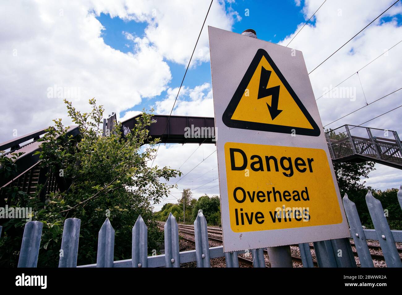 Danger Overhead Live Wire sign near a railway bridge Stock Photo