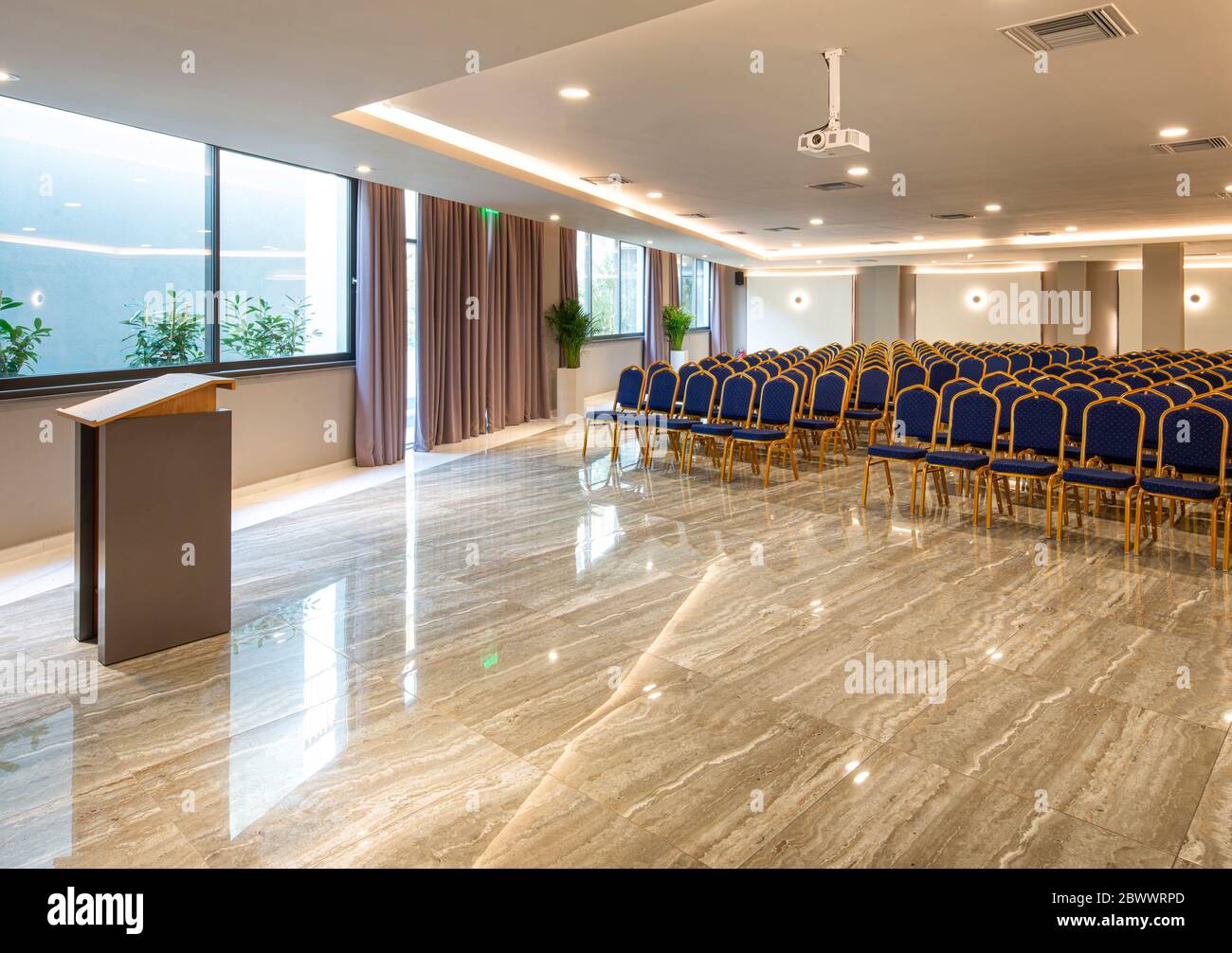 Modern auditorium interior with lecturer desk and rows of vintage chairs in luxury training center. Educational class background with copy space Stock Photo