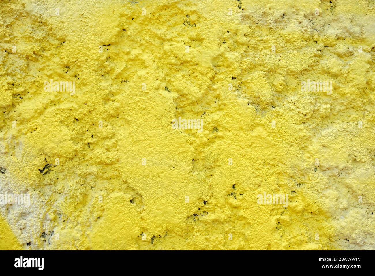 Yellow Spray Painting on Stucco Wall Texture Background. Stock Photo