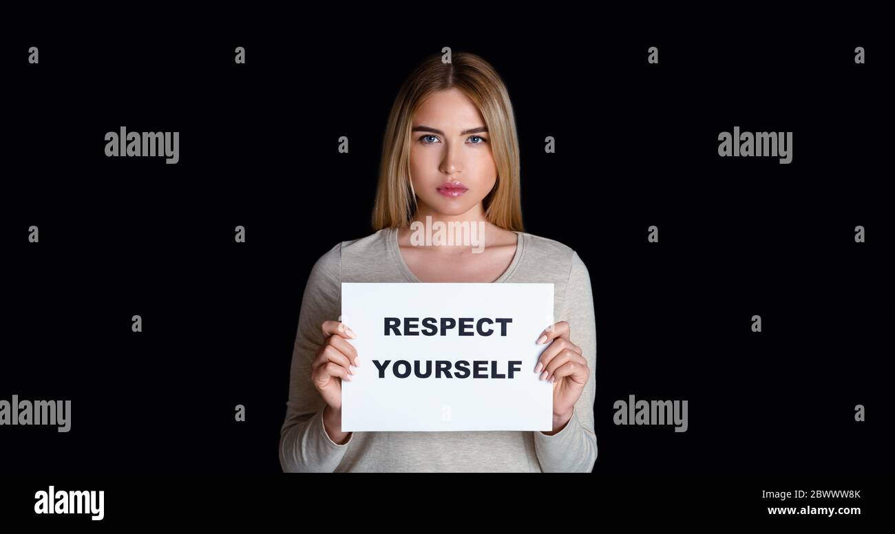 Girl holds sign with inscription respect yourself, free space Stock Photo