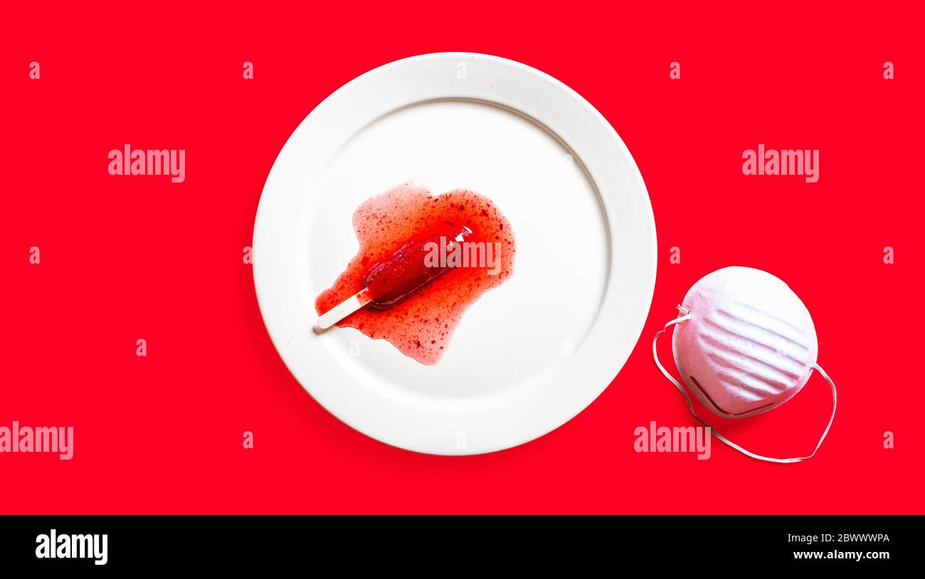 Delicious defrosted strawberry popsicles and medical mask over red background Stock Photo