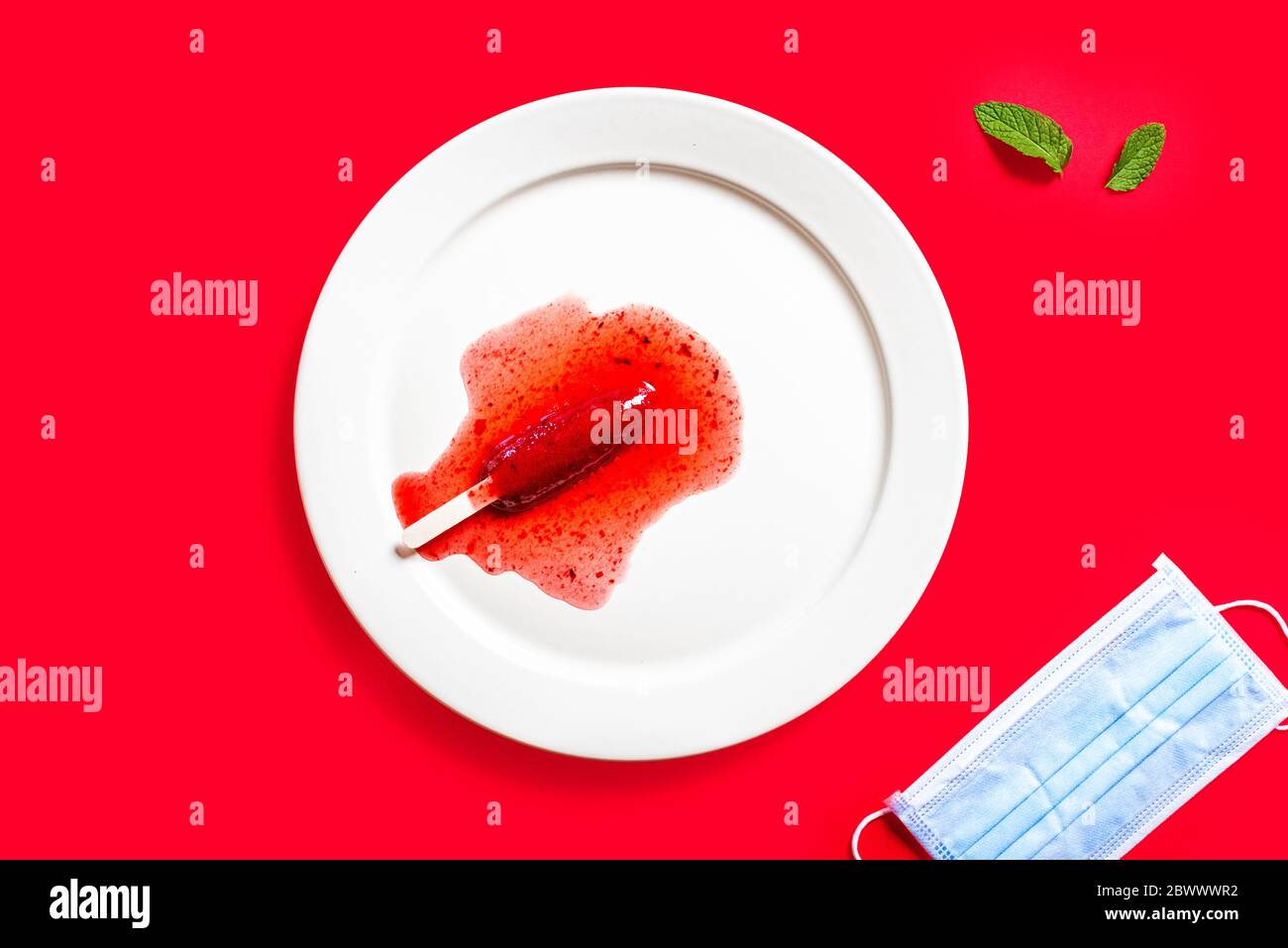 Delicious defrosted strawberry popsicles and medical mask over red background Stock Photo
