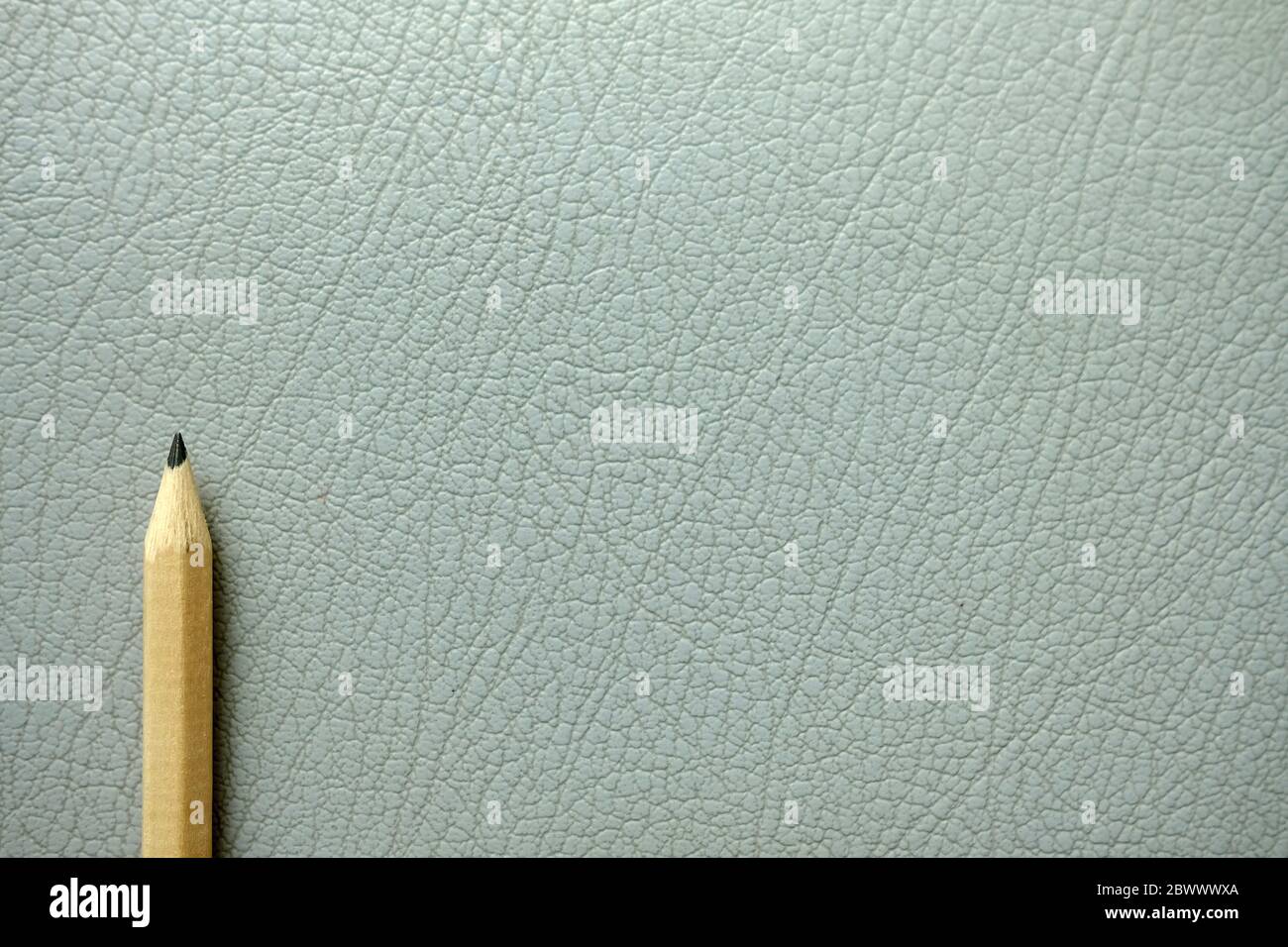 Pencil on Old Gray Leather Texture Background. Stock Photo